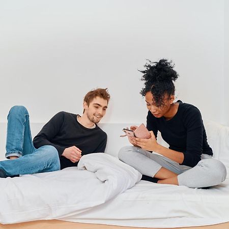 Mije Marais Hostel Paris Bagian luar foto A couple using their smartphones
