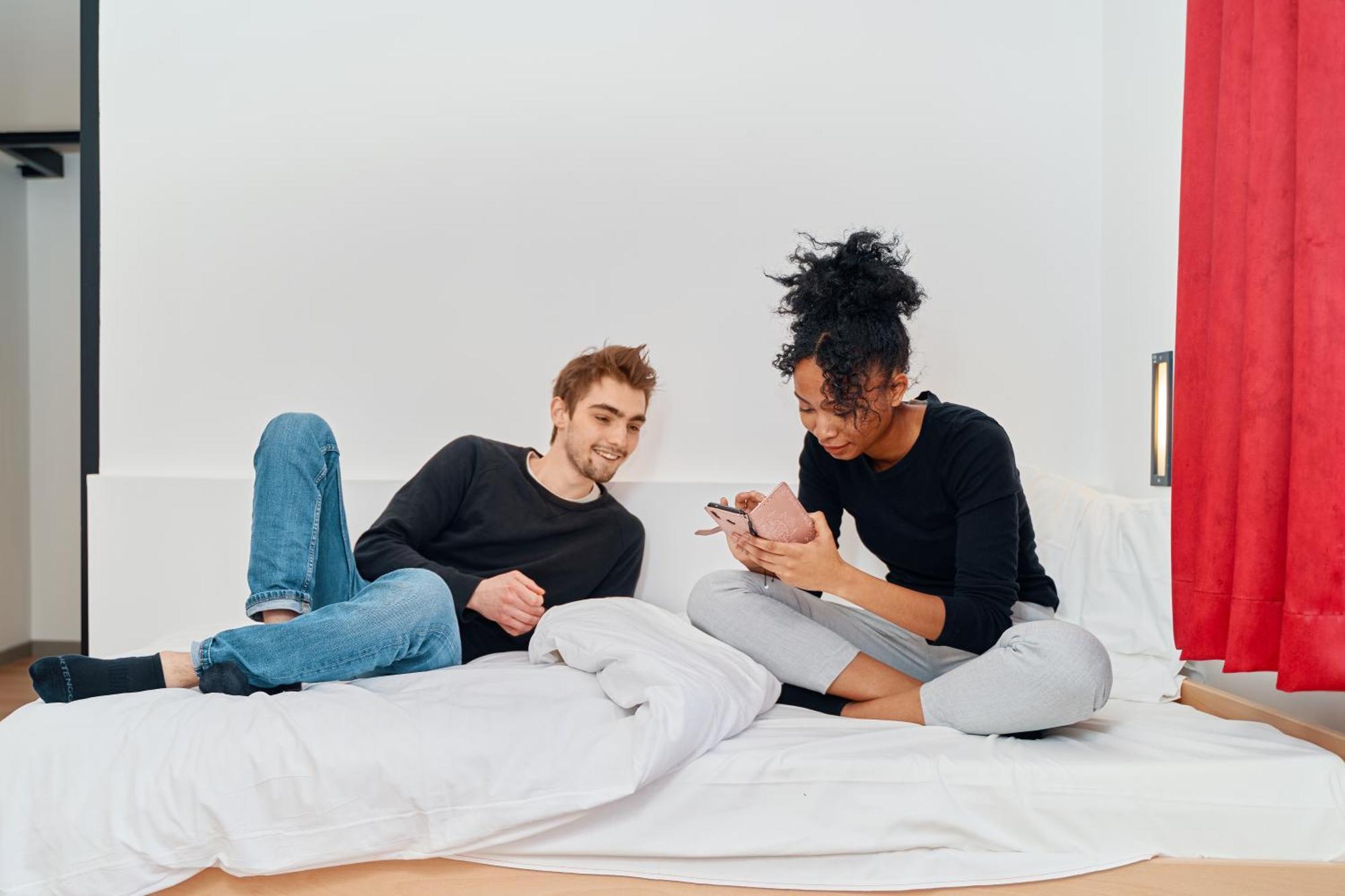 Mije Marais Hostel Paris Bagian luar foto A couple using their smartphones