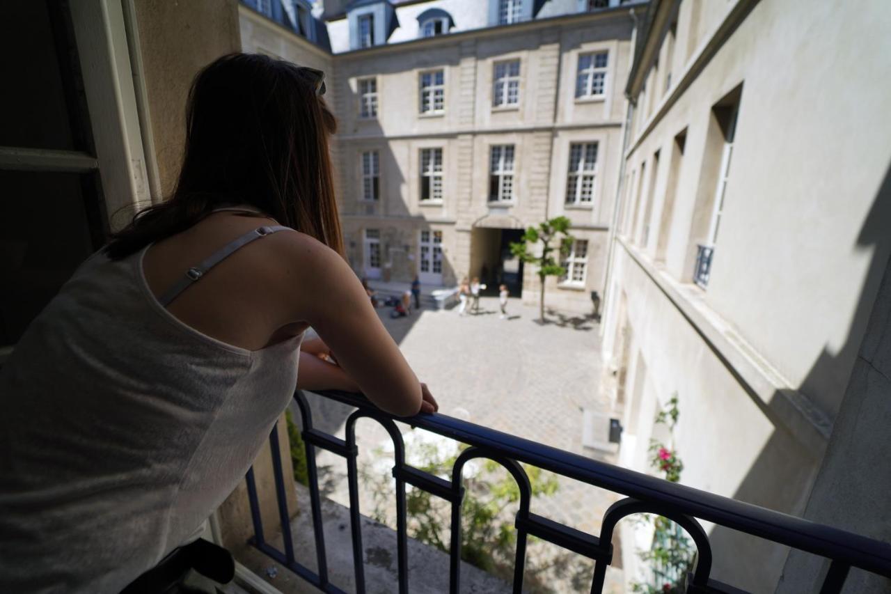 Mije Marais Hostel Paris Bagian luar foto A woman on a balcony